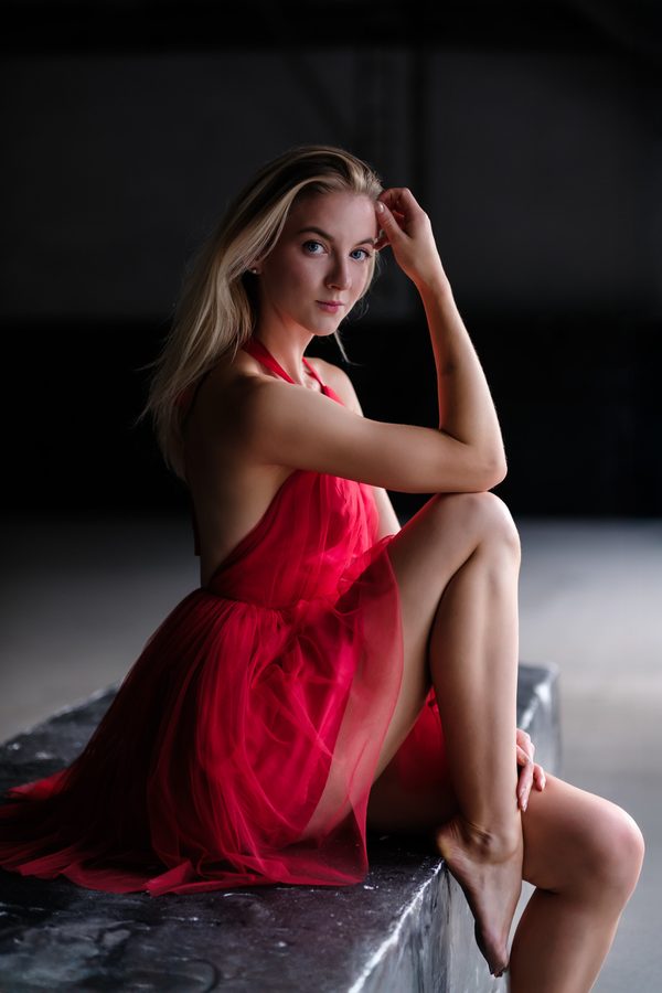 Red dress, seated in an industrial hall