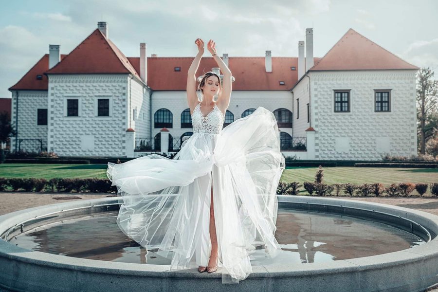 Bride with flowing skirt at a chateau fountain